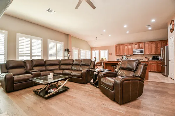 a living room with furniture kitchen view and a window