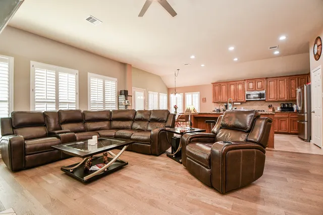 a living room with furniture kitchen view and a window