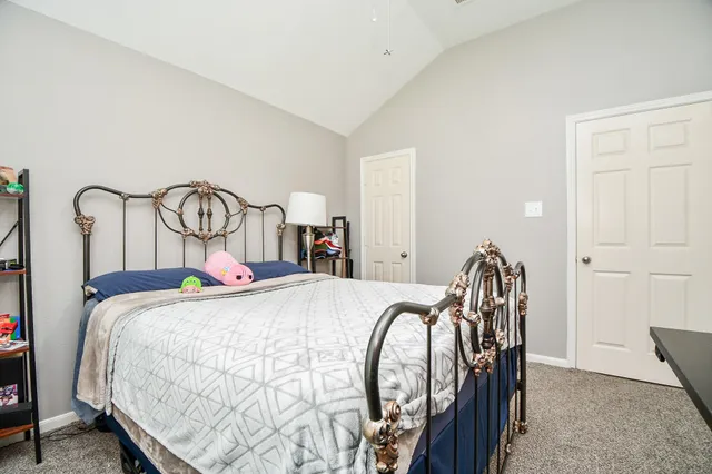a bed sitting in a bedroom next to a cabinet