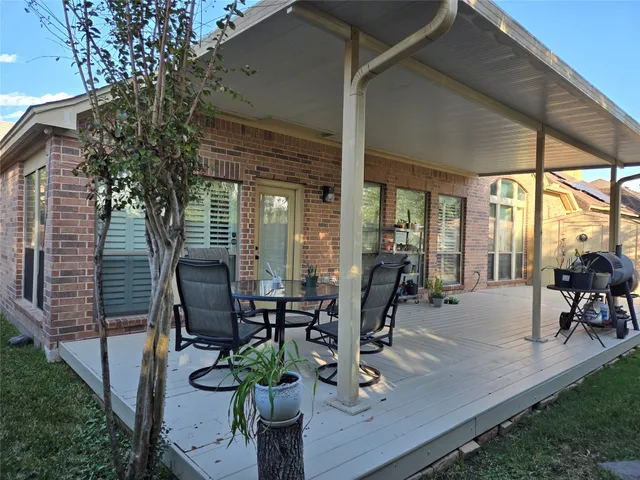 a view of a patio with table and chairs and potted plants