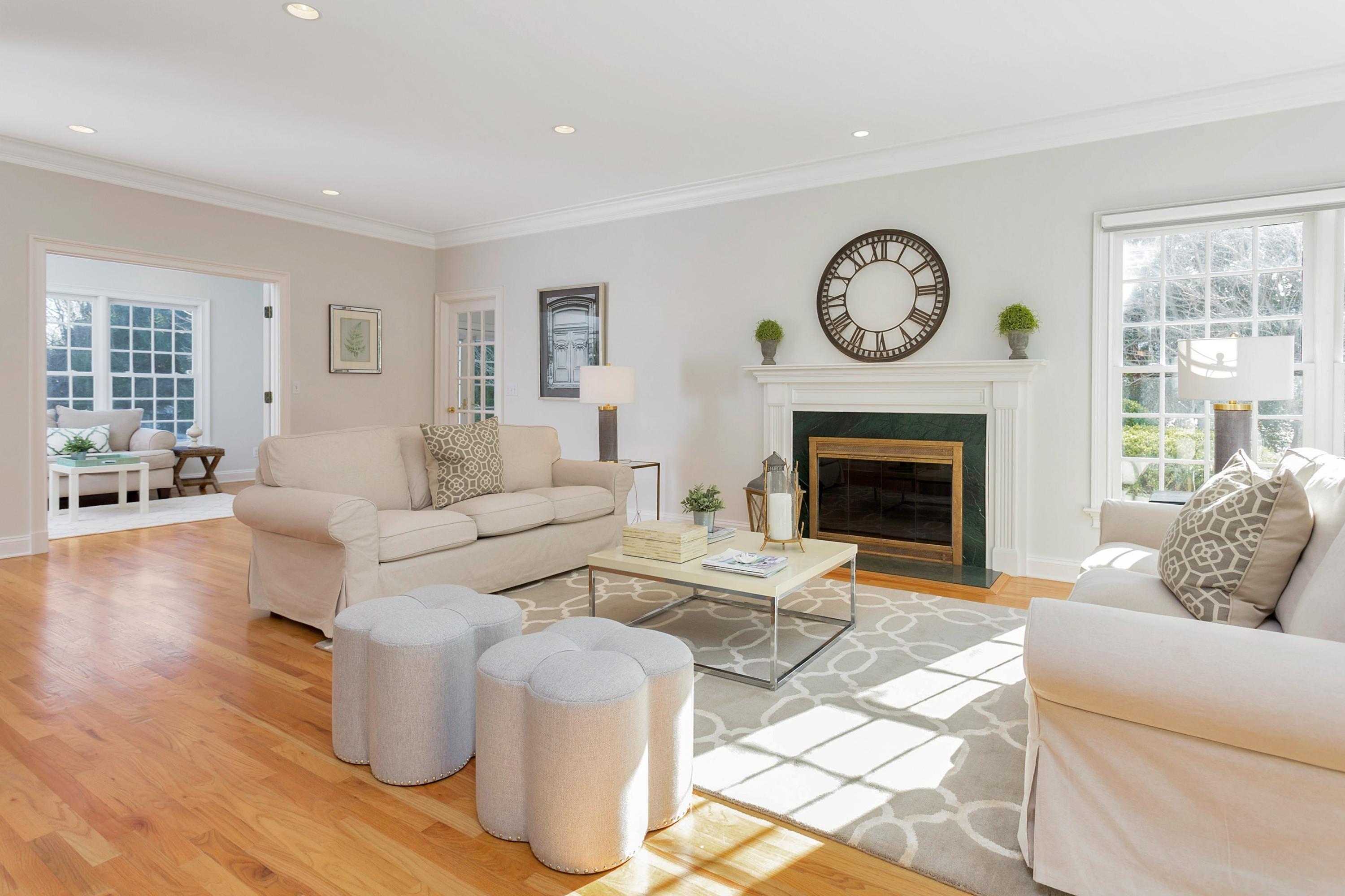 244 Hollow Tree Ridge Road Darien, CT 06820 - Photo 8 of 38 a living room with furniture a clock and a fireplace