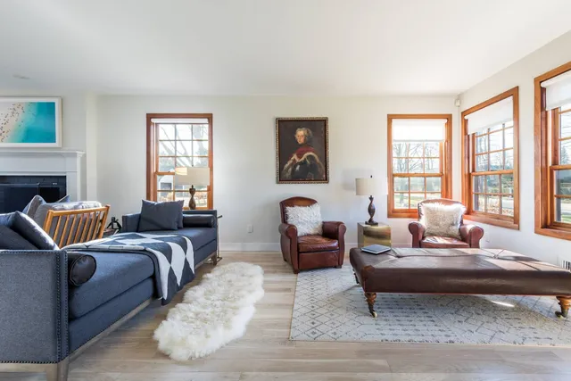 a living room with furniture large window and a lamp