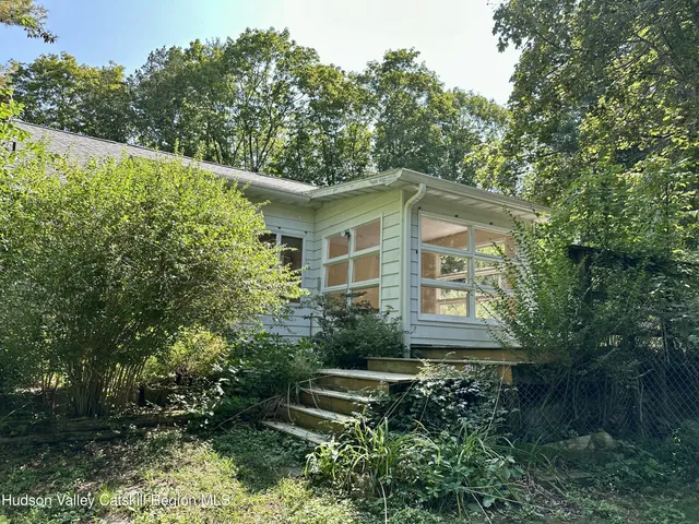 a yellow house with trees in front of it