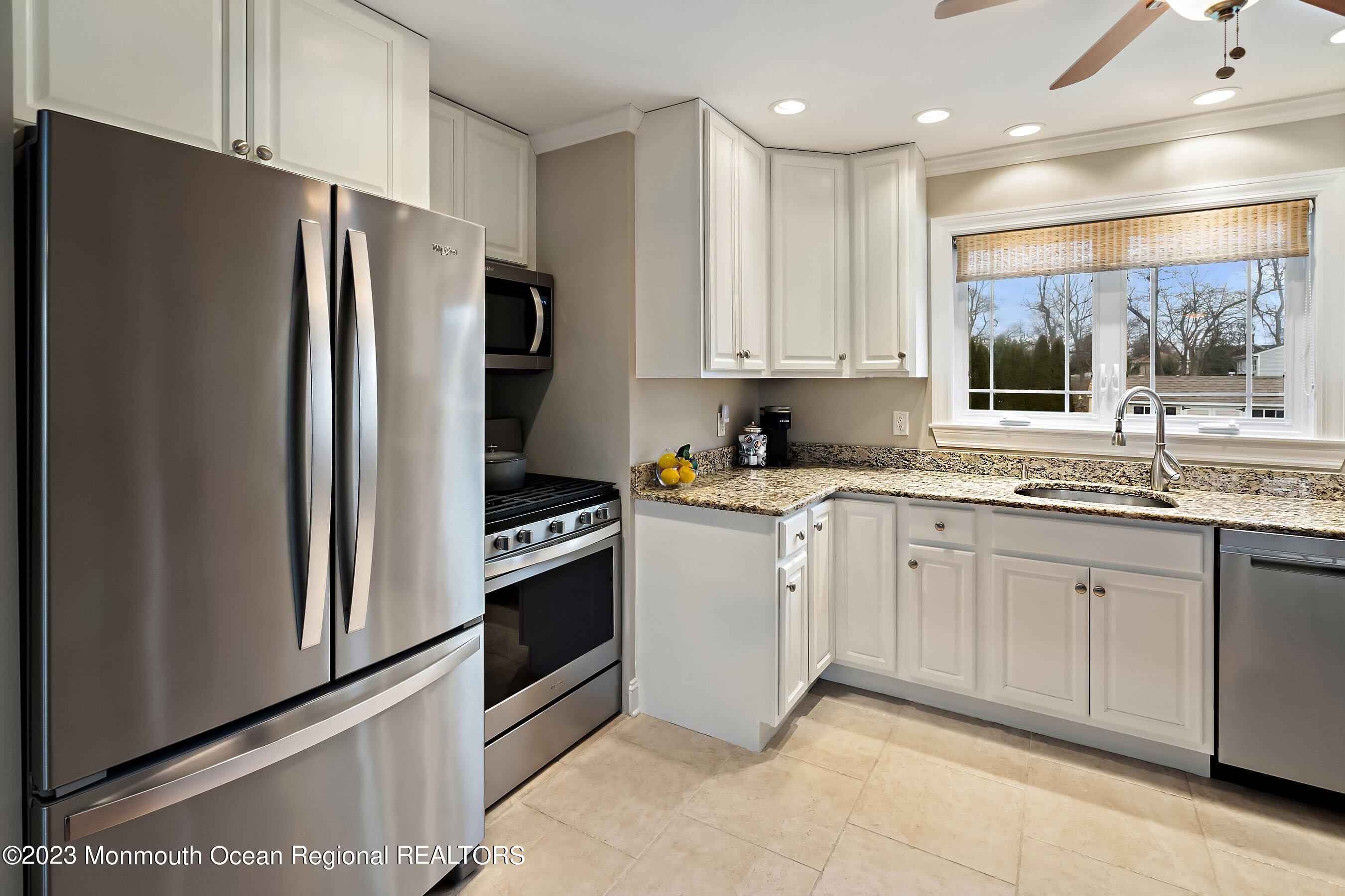 554 Hopping Road Belford, NJ 07718 - Photo 9 of 26 a kitchen with granite countertop white cabinets and stainless steel appliances