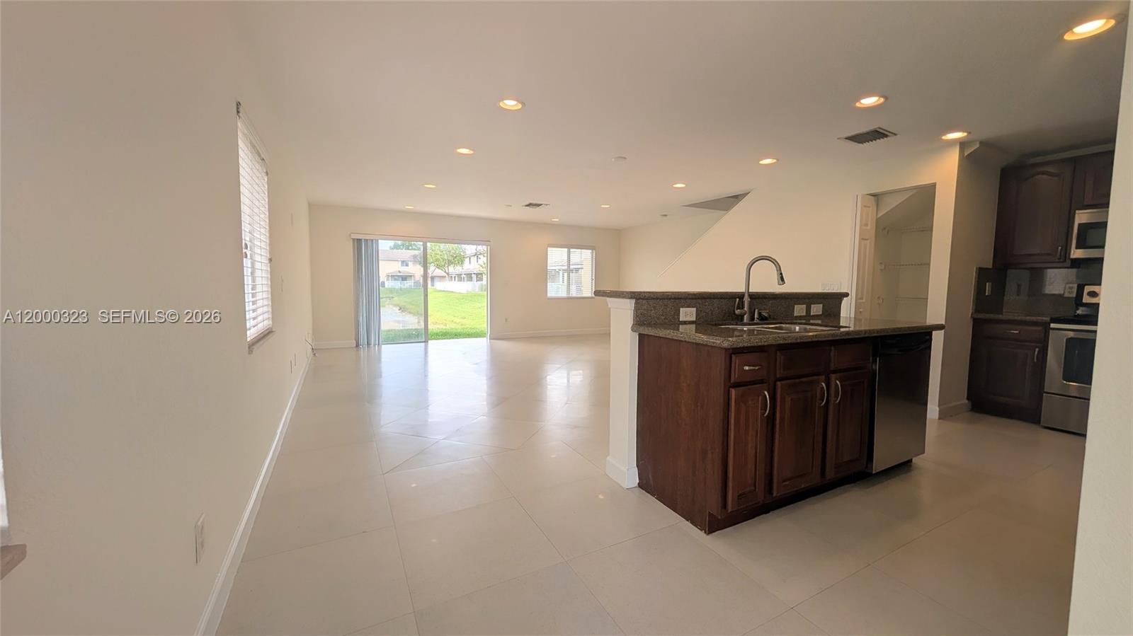 5910 Royal Way Tamarac, FL 33321 - Photo 12 of 36 a kitchen with stainless steel appliances granite countertop a sink and a stove