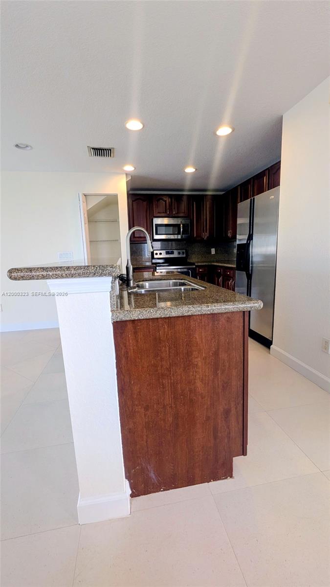 5910 Royal Way Tamarac, FL 33321 - Photo 13 of 36 a kitchen with stainless steel appliances granite countertop a refrigerator a sink a stove and a microwave