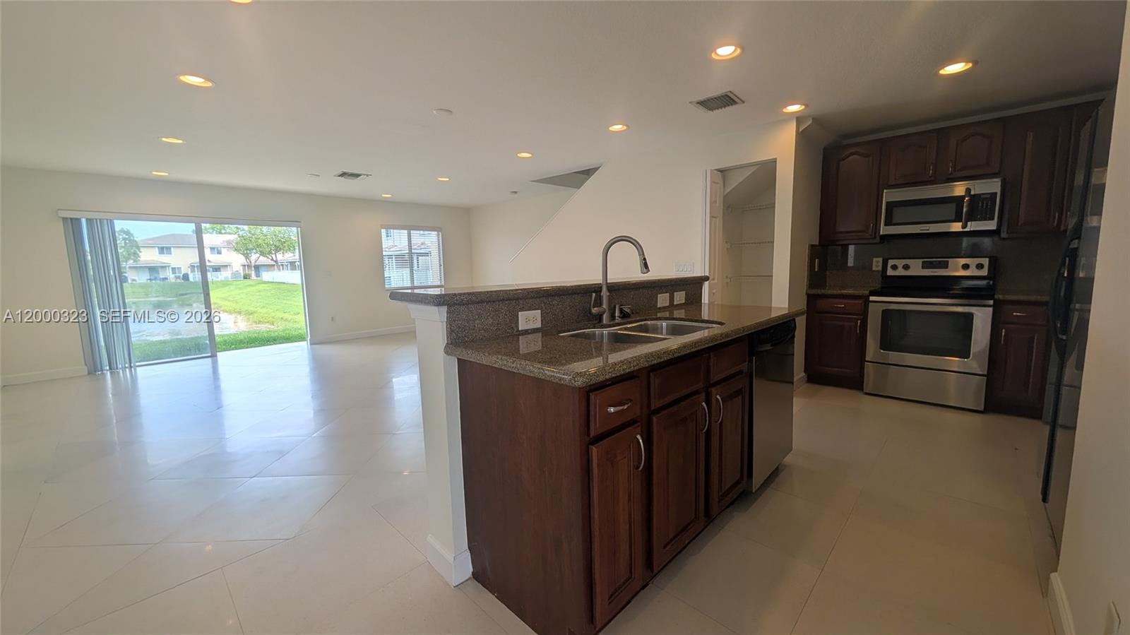 5910 Royal Way Tamarac, FL 33321 - Photo 3 of 36 a kitchen with stainless steel appliances granite countertop a stove a sink and a refrigerator