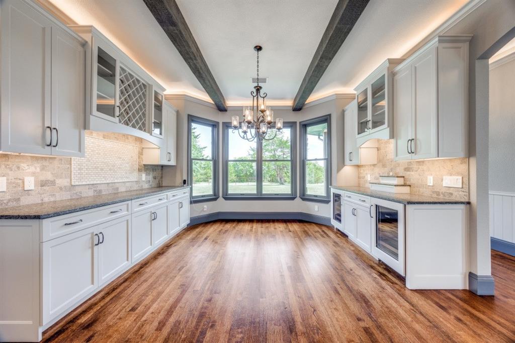 3244 Joe Davis Road Whitewright, TX 75491 - Photo 7 of 28 Kitchen featuring wine cooler, a chandelier, wood finished floors, dark stone counters, and beam ceiling