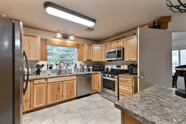 a kitchen with granite countertop a sink and a window