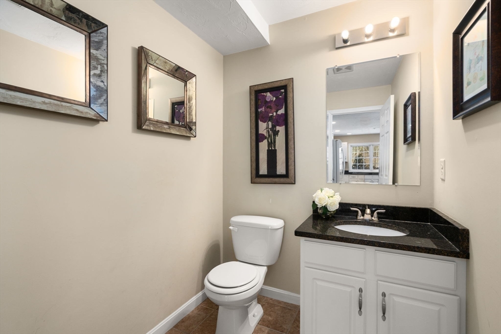 28 Patriots Boulevard, Unit 28 Hopkinton, MA 01748 - Photo 11 of 28 a bathroom with a granite countertop toilet sink and mirror