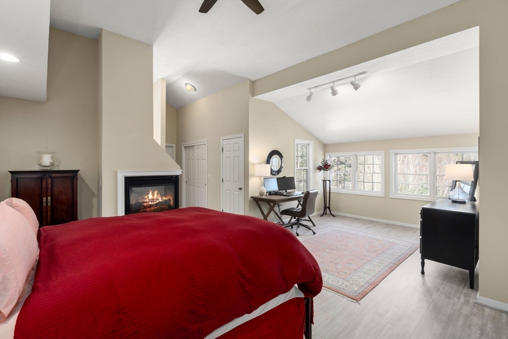 28 Patriots Boulevard, Unit 28 Hopkinton, MA 01748 - Photo 14 of 28 a spacious bedroom with a bed a table and chair with a bookshelf