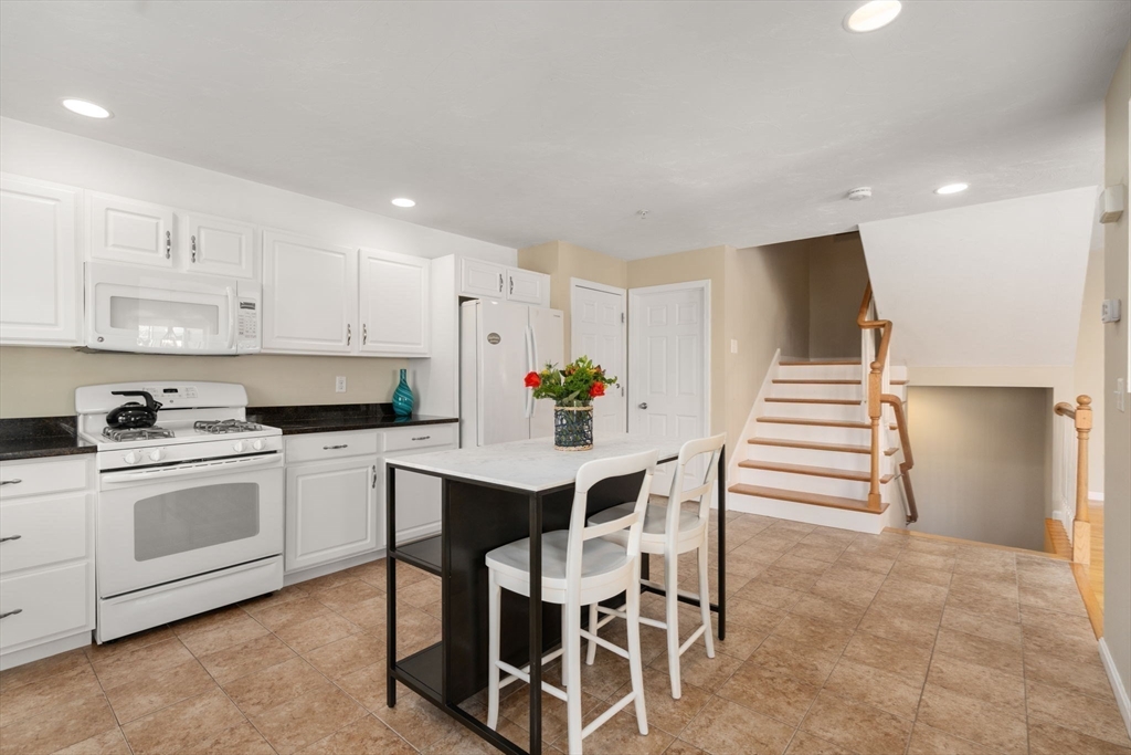 28 Patriots Boulevard, Unit 28 Hopkinton, MA 01748 - Photo 3 of 28 a kitchen with stainless steel appliances white cabinets and wooden floor