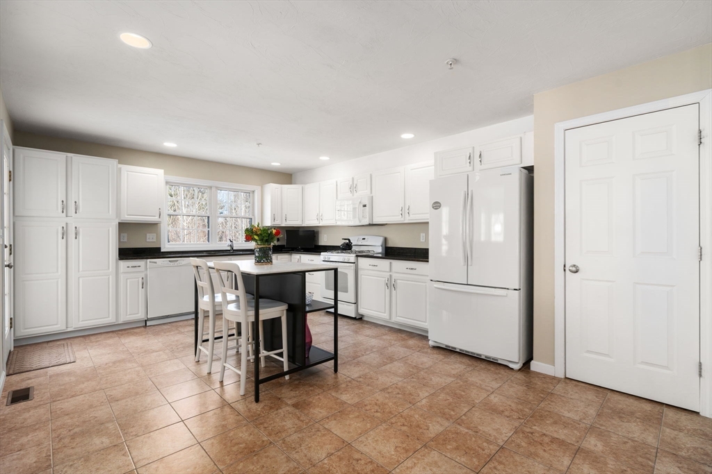 28 Patriots Boulevard, Unit 28 Hopkinton, MA 01748 - Photo 4 of 28 a kitchen with refrigerator and cabinets