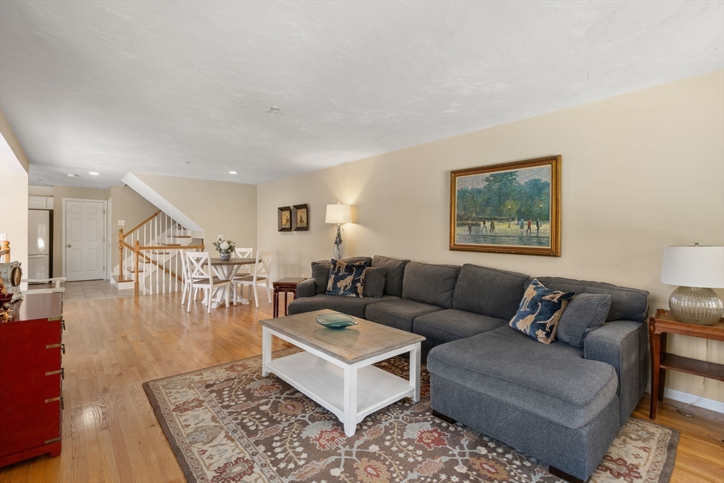 28 Patriots Boulevard, Unit 28 Hopkinton, MA 01748 - Photo 9 of 28 a living room with furniture and a view of kitchen