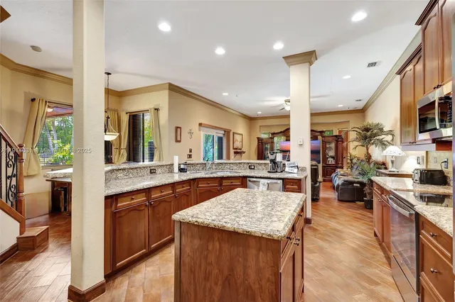 a kitchen with stainless steel appliances granite countertop sink stove top oven and cabinets
