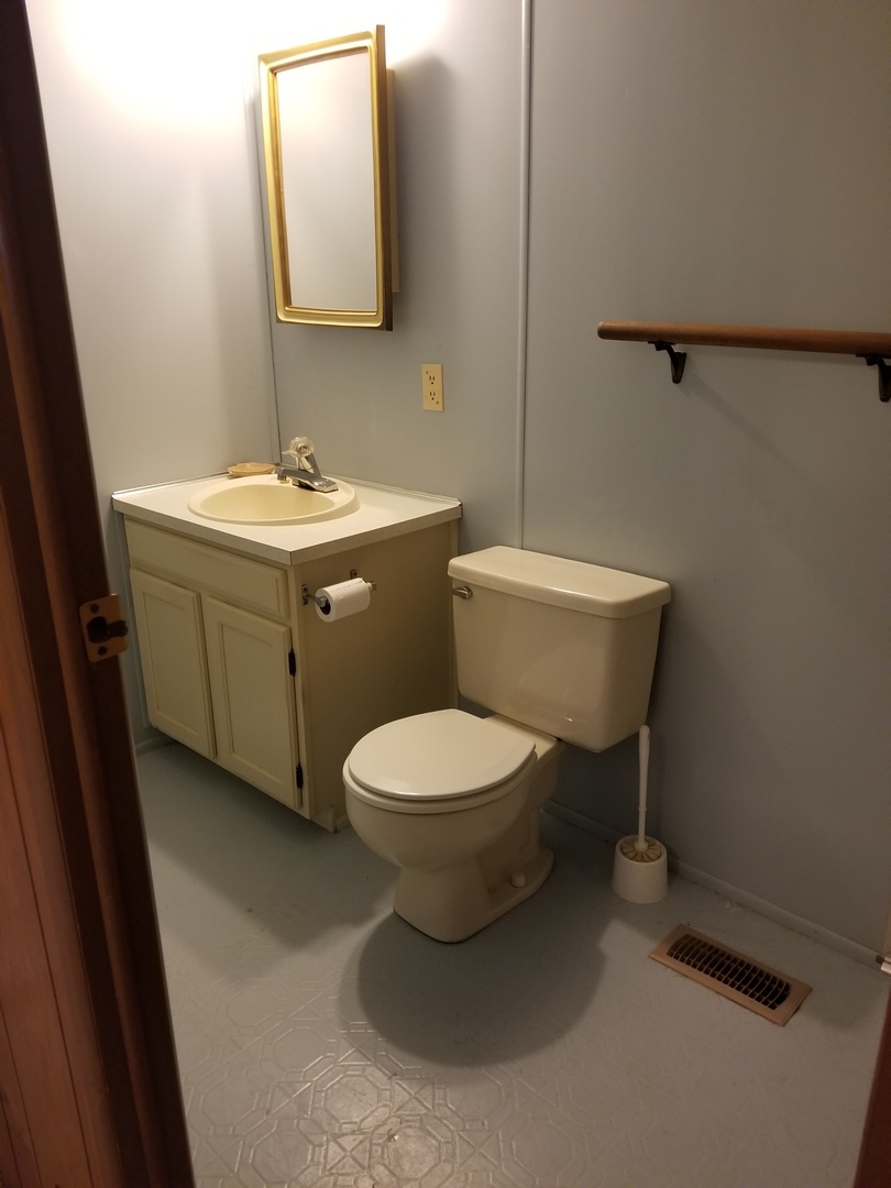 259 Parkwood Road Elgin, IL 60123 - Photo 12 of 18 a bathroom with a toilet a sink and mirror