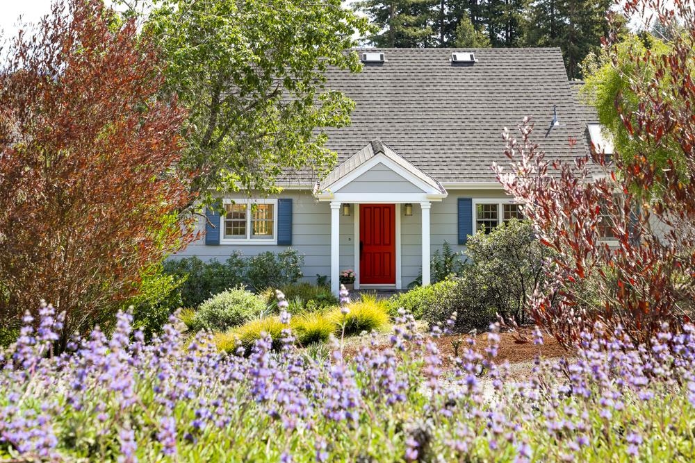 a front view of a house with a yard and a garden