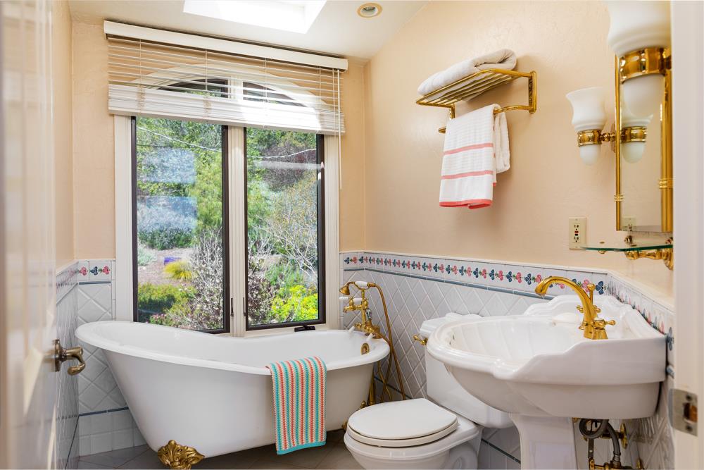 223 Nehf Lane Soquel, CA 95073 - Photo 15 of 34 a bathroom with a white bath tub sitting next to a white sink and a toilet