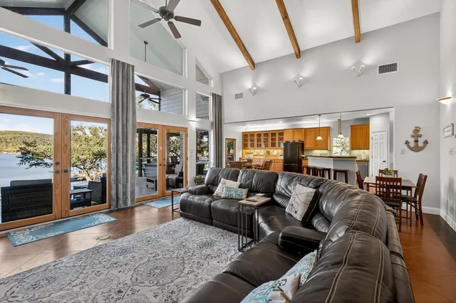 a living room with furniture large windows and wooden floor