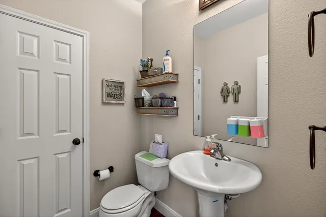 a bathroom with a sink a toilet and mirror