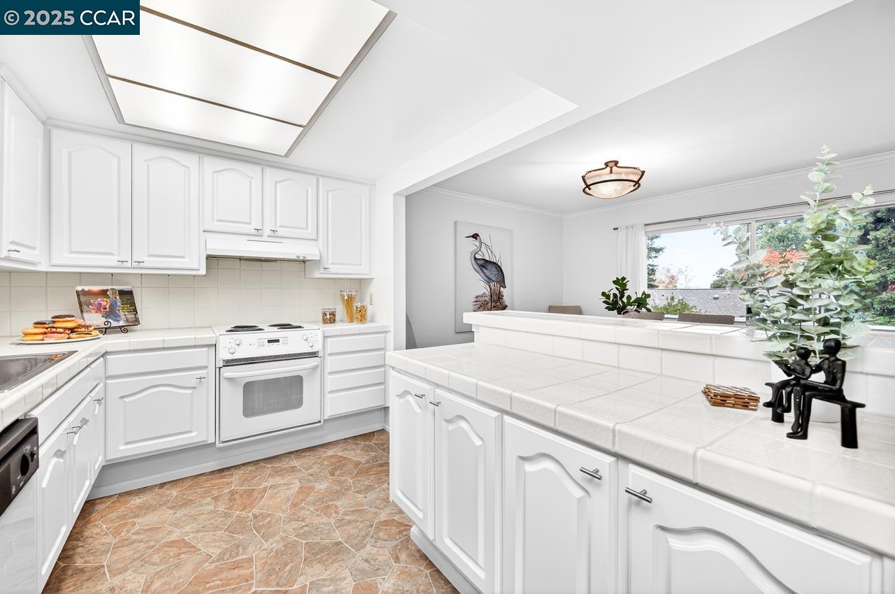 1400 Ptarmigan Drive, Unit 2 Walnut Creek, CA 94595 - Photo 13 of 44 a kitchen with granite countertop a sink and white cabinets