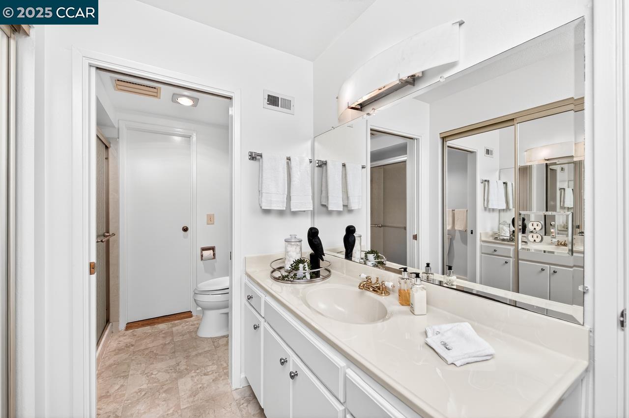 1400 Ptarmigan Drive, Unit 2 Walnut Creek, CA 94595 - Photo 17 of 44 a bathroom with a sink vanity granite tub shower and a mirror