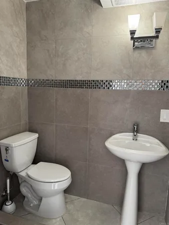 a bathroom with a sink toilet and a mirror