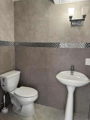 a bathroom with a sink toilet and a mirror