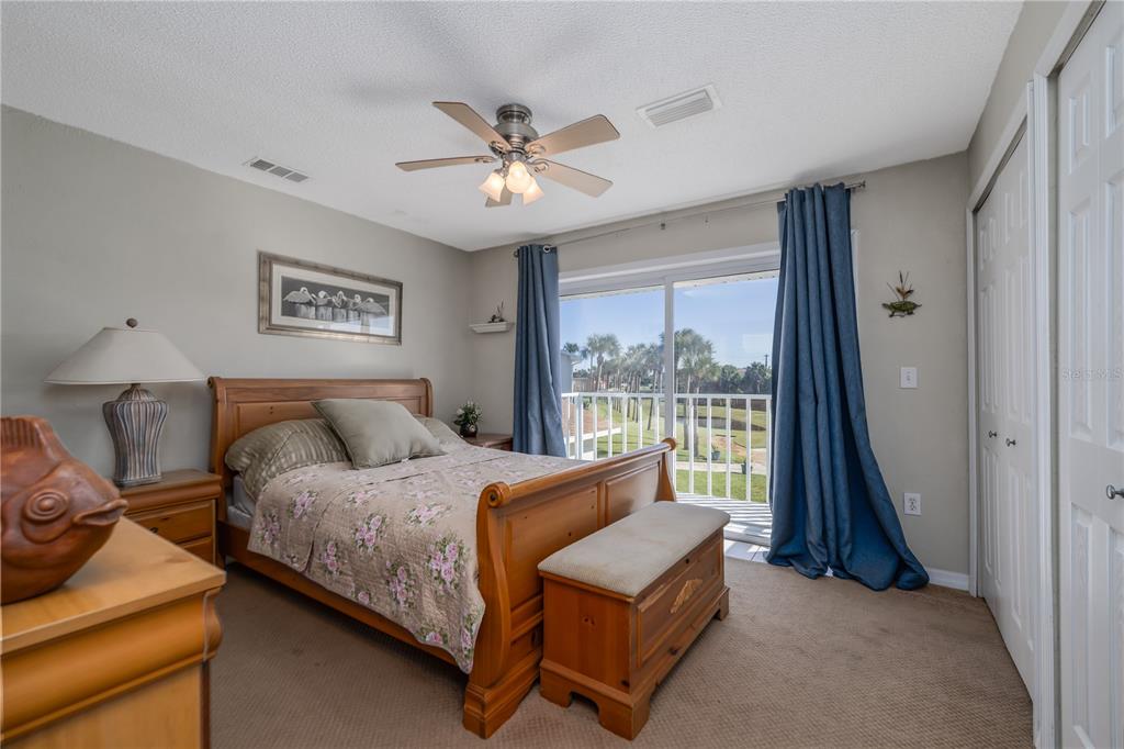 4786 South Atlantic Avenue, Unit 4B Ponce Inlet, FL 32127 - Photo 15 of 22 a bedroom with a bed and a chandelier