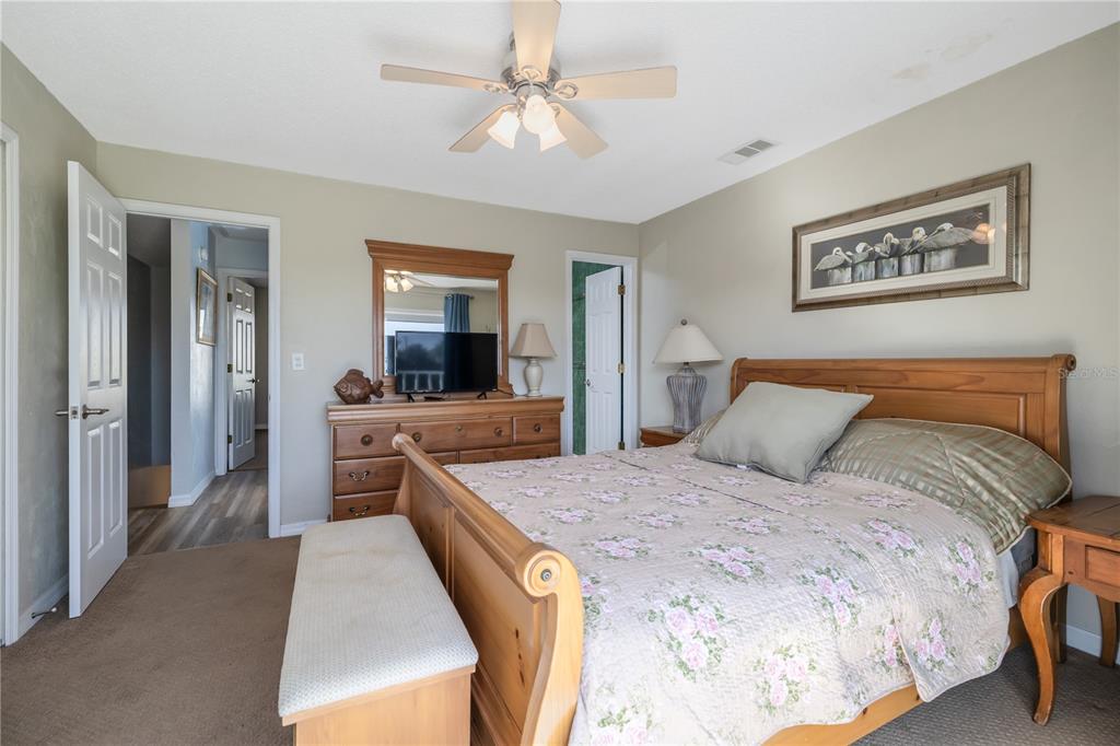 4786 South Atlantic Avenue, Unit 4B Ponce Inlet, FL 32127 - Photo 16 of 22 a bedroom with a bed and a chandelier