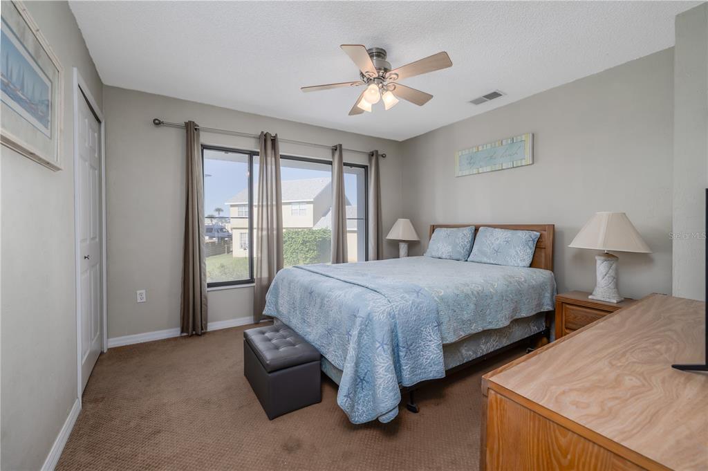 4786 South Atlantic Avenue, Unit 4B Ponce Inlet, FL 32127 - Photo 19 of 22 a spacious bedroom with a bed and a chandelier