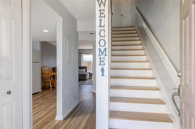 a view of a hallway with wooden floor and entryway