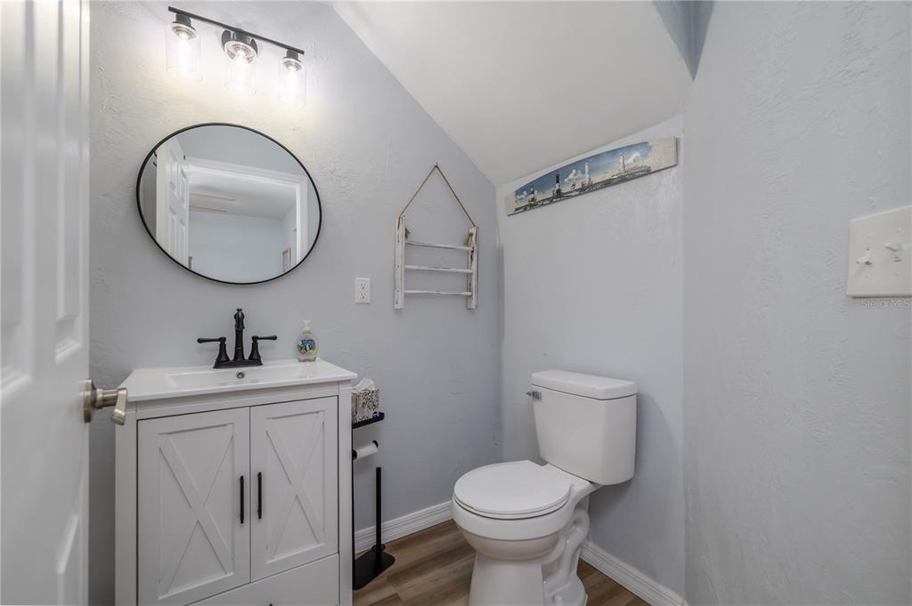 4786 South Atlantic Avenue, Unit 4B Ponce Inlet, FL 32127 - Photo 8 of 22 a bathroom with a toilet sink vanity and mirror