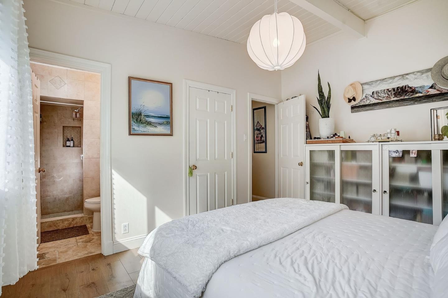 274 Hillside Drive Pacifica, CA 94044 - Photo 20 of 56 a bedroom with a large bed and a chandelier