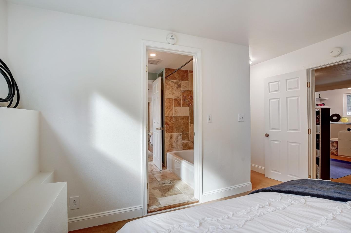 274 Hillside Drive Pacifica, CA 94044 - Photo 31 of 56 a bedroom with a bed and a glass door