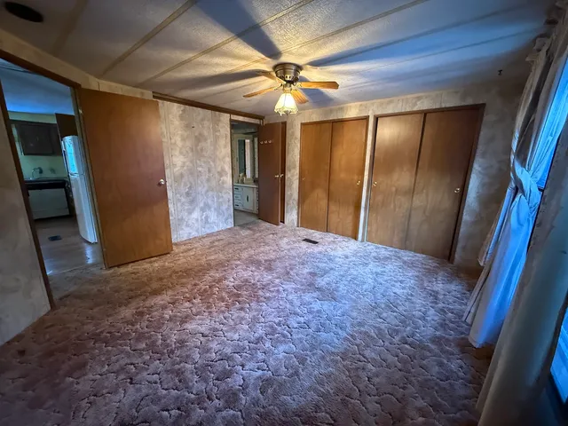 a view of a livingroom with a ceiling fan and window
