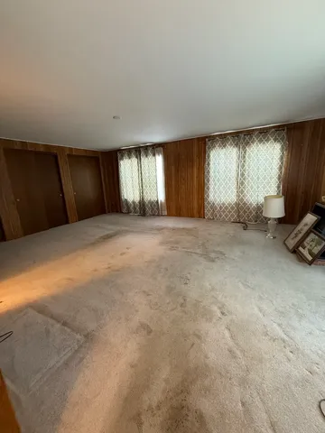 a view of an empty room with a window and a kitchen counter top space