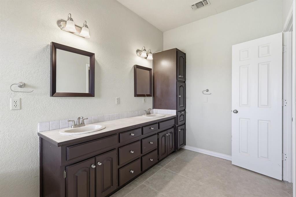 211 Bayne Road Haslet, TX 76052 - Photo 17 of 29 a bathroom with a double vanity sink and a mirror