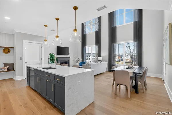 a large kitchen with stainless steel appliances a table chairs and a view of living room