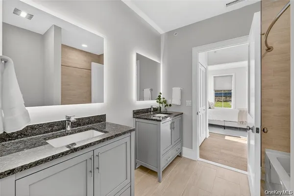 a bathroom with a granite countertop sink and a mirror