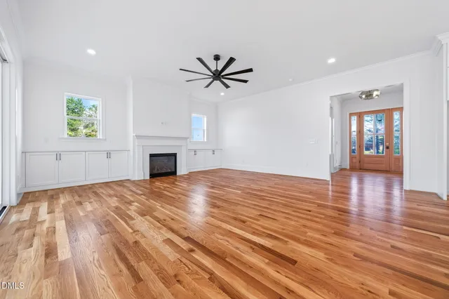 a view of empty room with wooden floor and fireplace