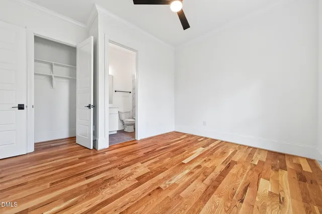 a view of an empty room with wooden floor and closet