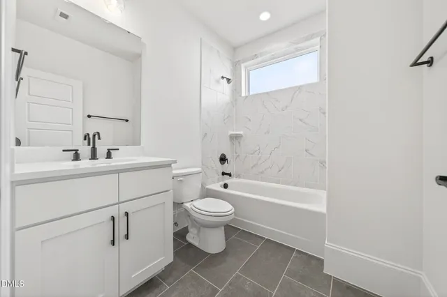 a bathroom with a sink toilet vanity and shower