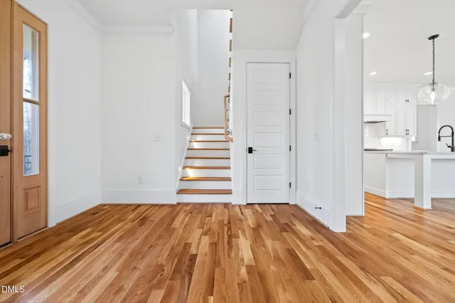 a view of empty room with wooden floor and fireplace