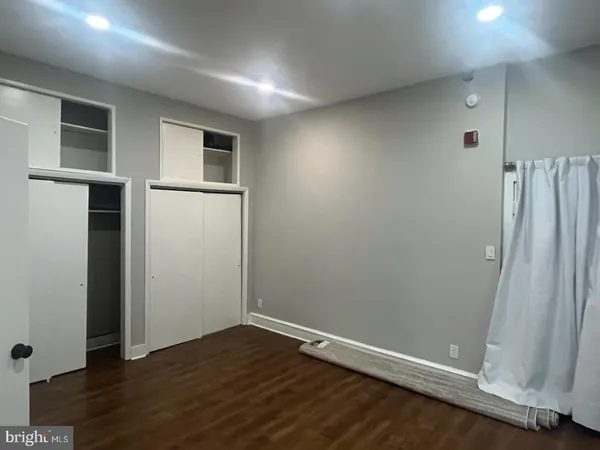 an empty room with wooden floor and a window
