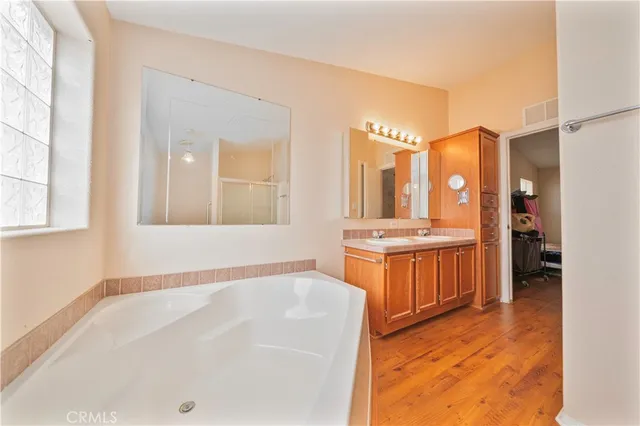 a bathroom with a tub sink and mirror