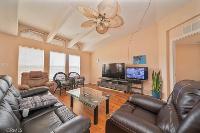 a living room with furniture a flat screen tv and a large window
