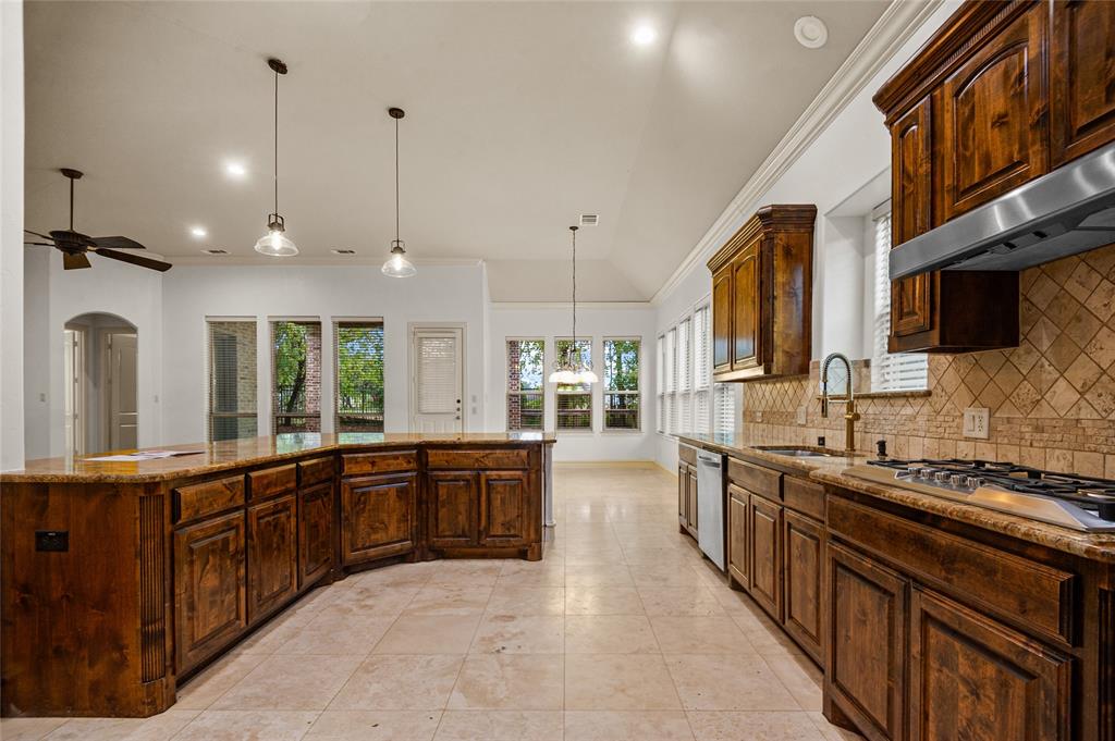961 Deer Run Prosper, TX 75078 - Photo 12 of 34 a large kitchen with stainless steel appliances granite countertop a stove and large cabinets