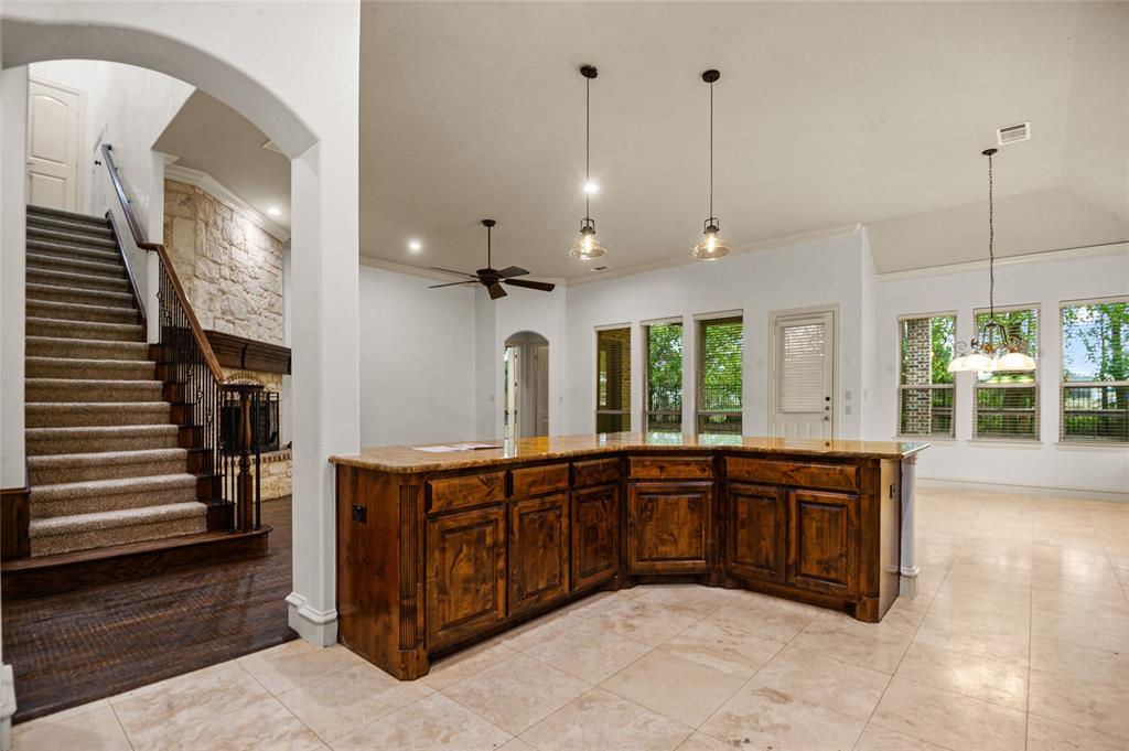 961 Deer Run Prosper, TX 75078 - Photo 13 of 34 a large kitchen with stainless steel appliances granite countertop a sink and a wooden floor