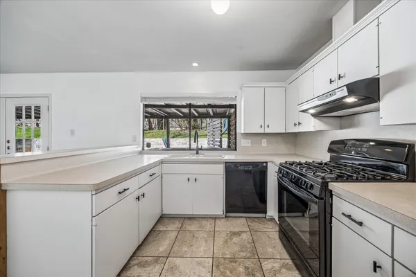 a kitchen with stainless steel appliances granite countertop a sink and a stove